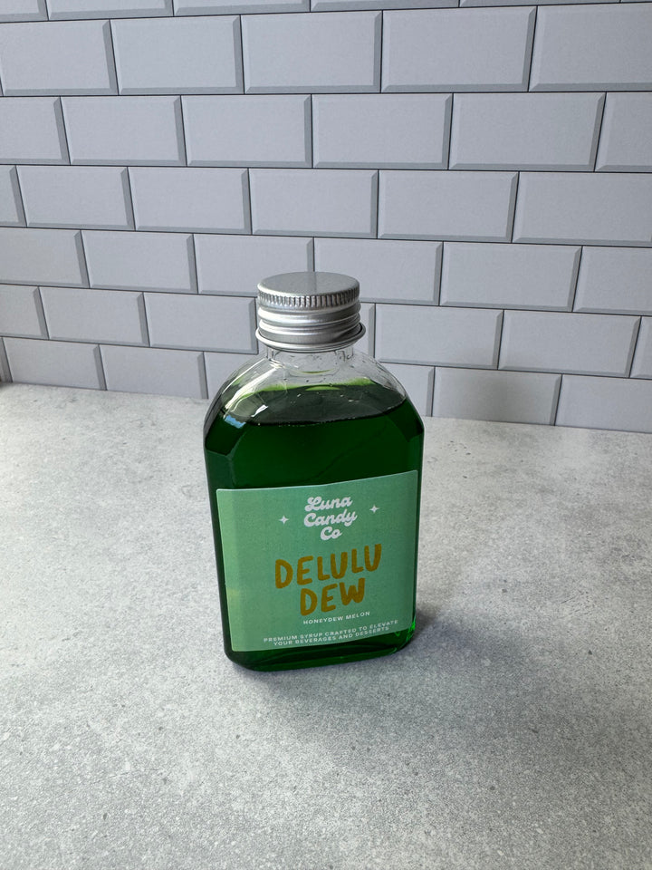 Green Delulu Dew Luna Candy Co Drink Syrup agains white subway tile
