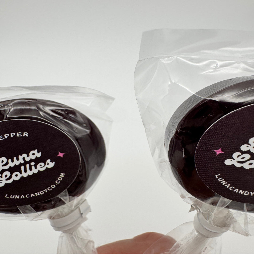 hand holding two Dr. Pepper inspired lollipop candy