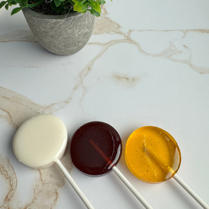 Close-up of Honey Bee baby shower lollipop favor with yellow and white swirl