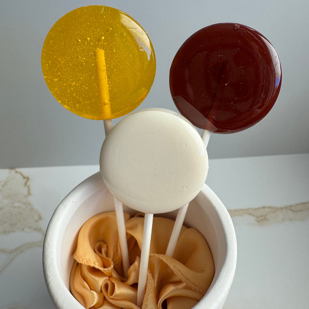 Honey Bee themed lollipop favors arranged for a baby shower candy table