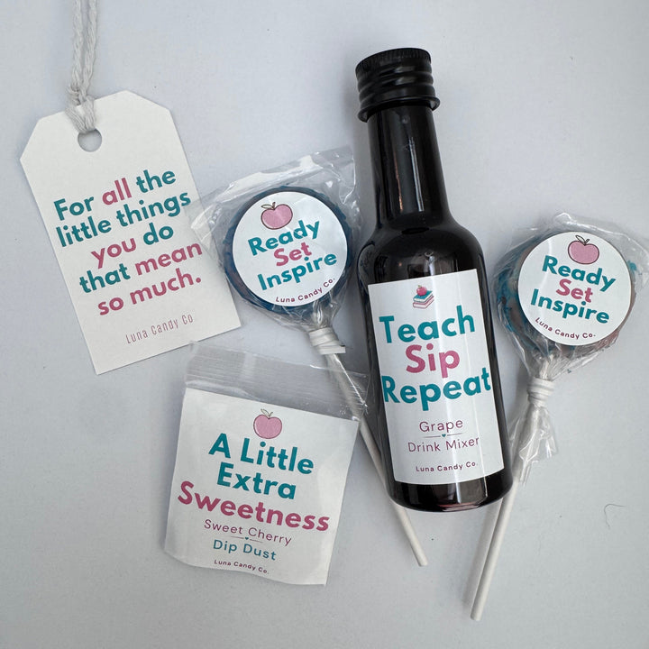 A gift set of personalized drink accessories including a black bottle labeled with grape drink syrup &