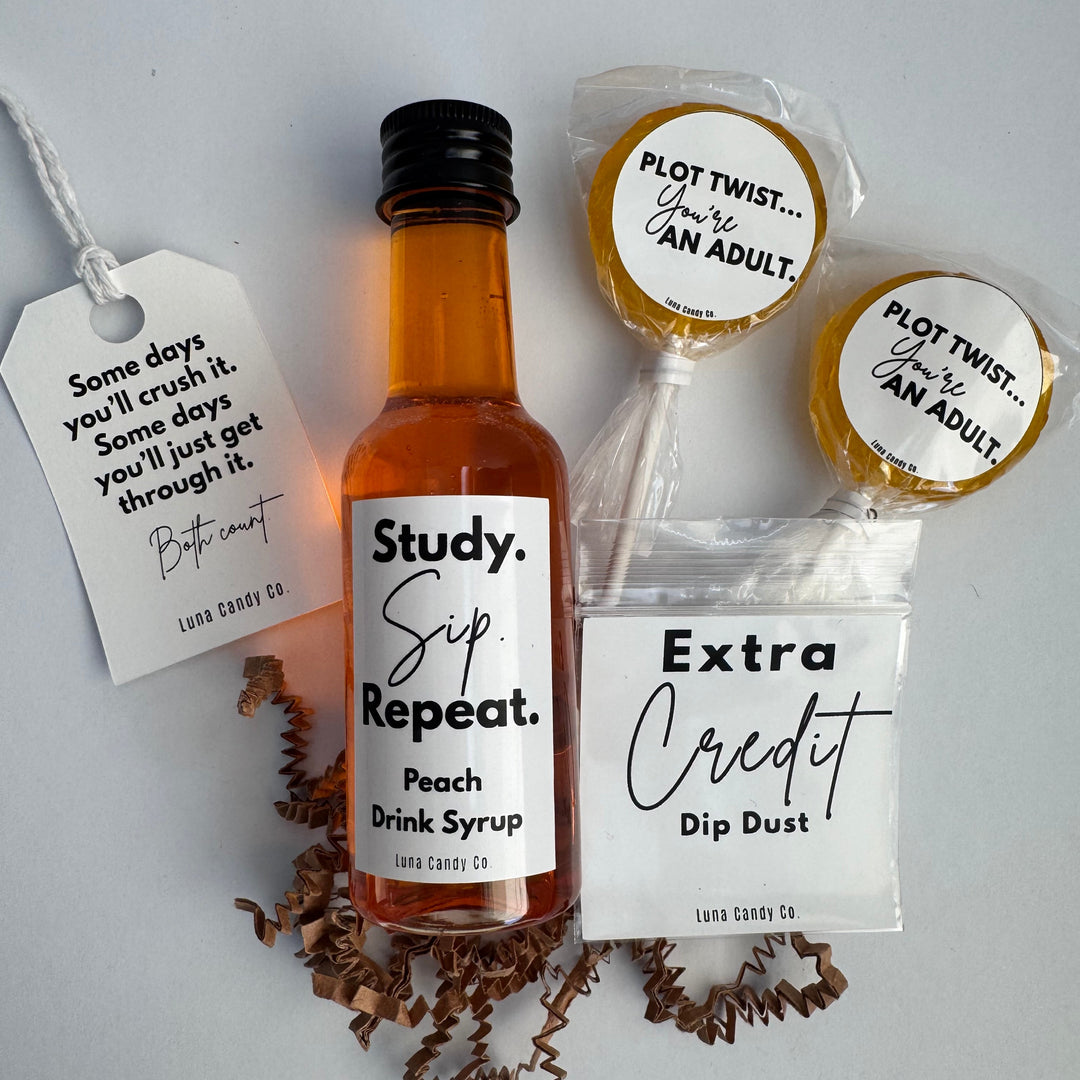 A gift set for college students from Land Candy Co. featuring a mini bottle of peach drink syrup with study, sip, repeat, two lollipops with 'PLOT TWIST, a dip dust with extra credit and hang tag.