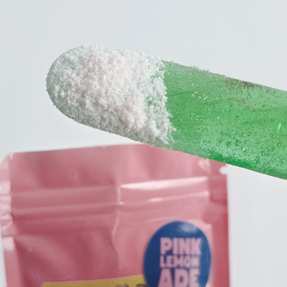 Done Dusted sour candy pucks with pink lemonade flavor on a white background
