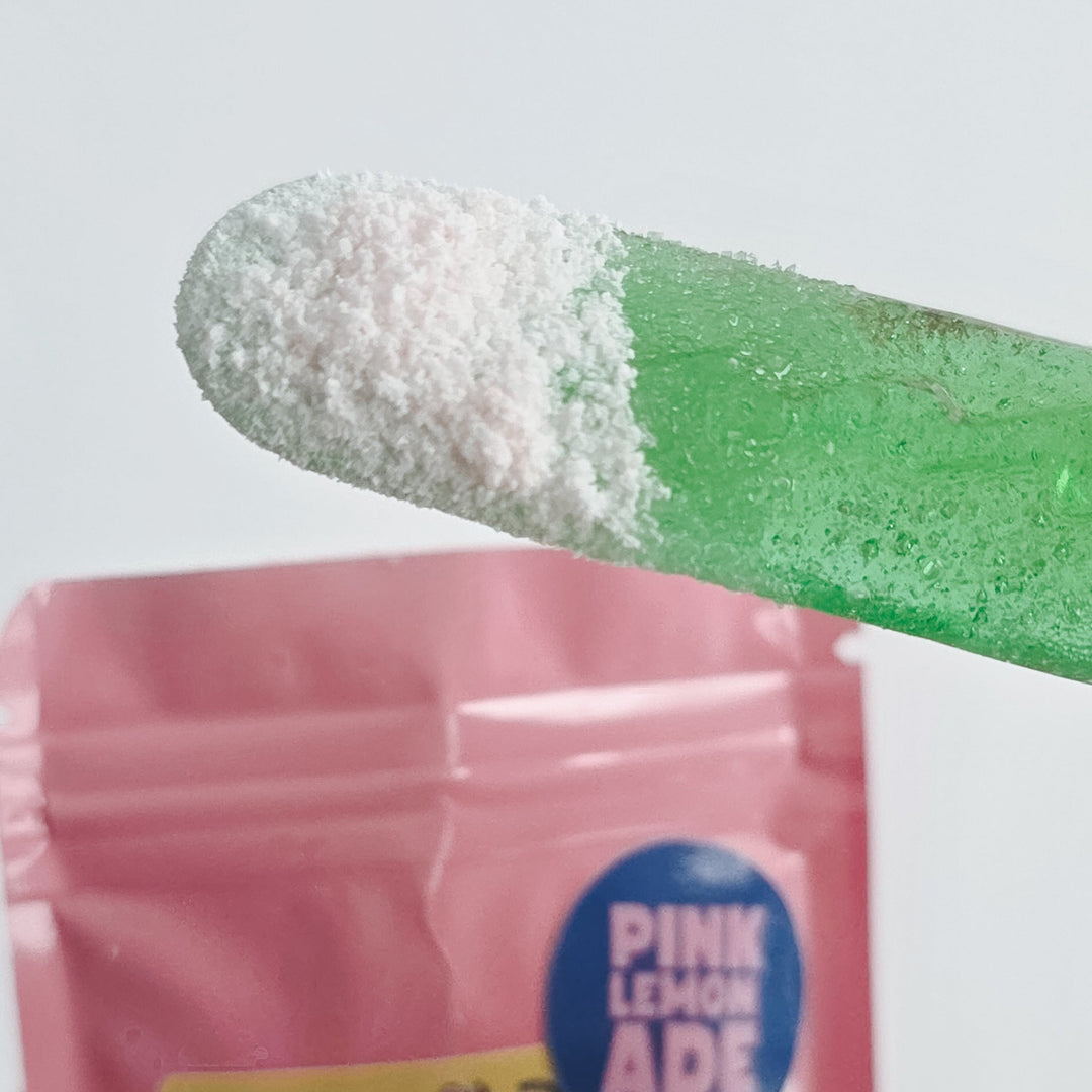 Done Dusted sour candy pucks with pink lemonade flavor on a white background