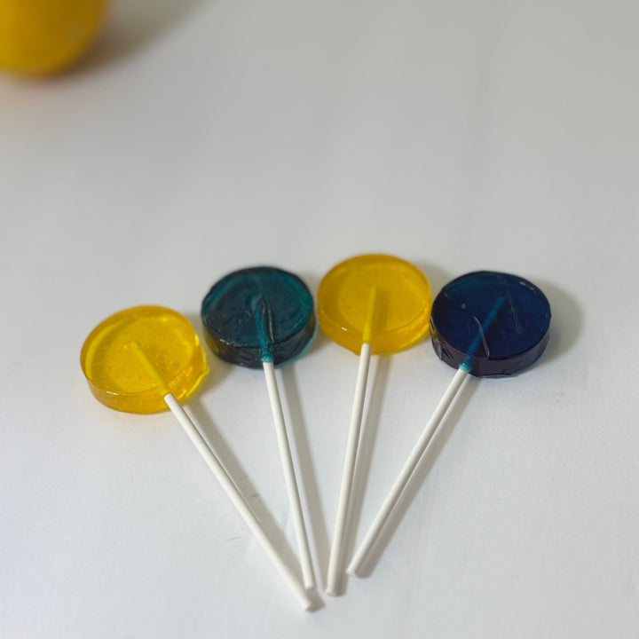 Four lollipops with yellow and blue tops on a white background