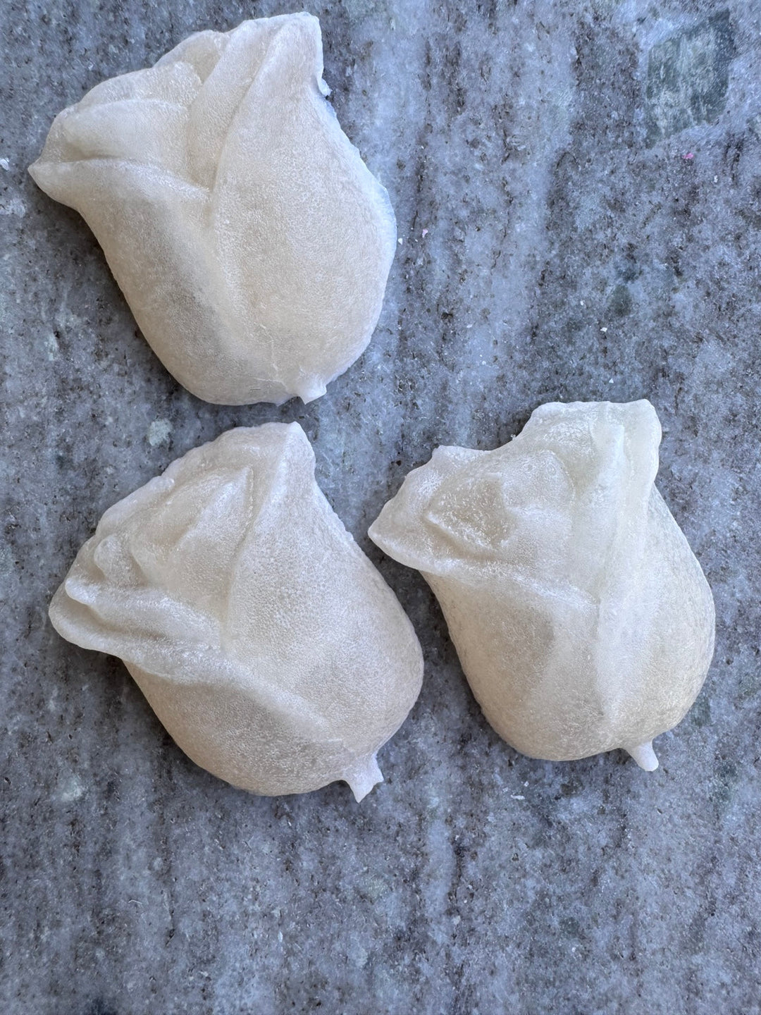 Three pearly white rose-shaped lychee kohakutou candies