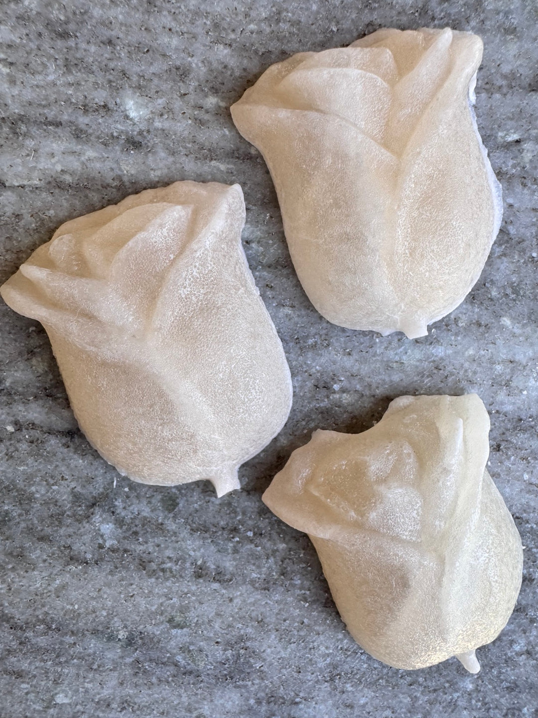 Overhead view of pearly white rose-shaped lychee kohakutou candies