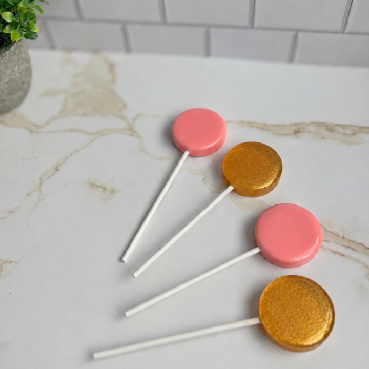 Pink and gold lollipops fanned out for a quinceañera candy table